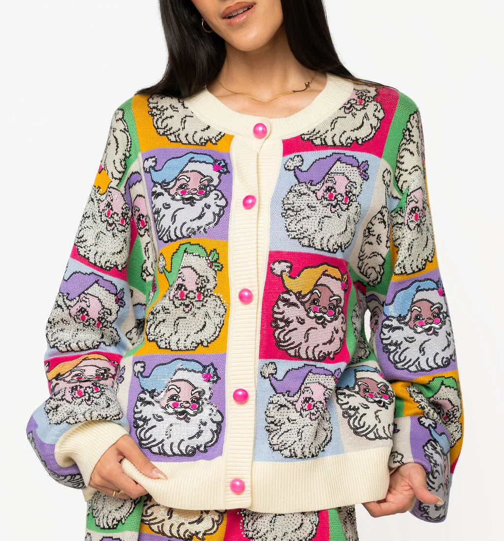 A woman wearing a colorful knit cardigan and by queen of sparkles new christmas collection. playful cartoon santa vintage style all over